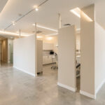 Aménagement cabinet dentaire : travaux, normes et parcours patient Intérieur d’un cabinet dentaire moderne en travaux, avec des cloisons neuves, un éclairage soigné et une circulation lumineuse, sans personnes.